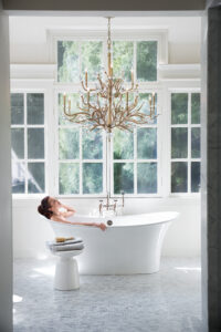 Chandelier bathroom lighting fixture hanging over bathtub