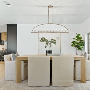 Elegant gold chandelier light from Franklin Lighting hanging over a stylish dining room table, casting a warm, inviting light throughout the space