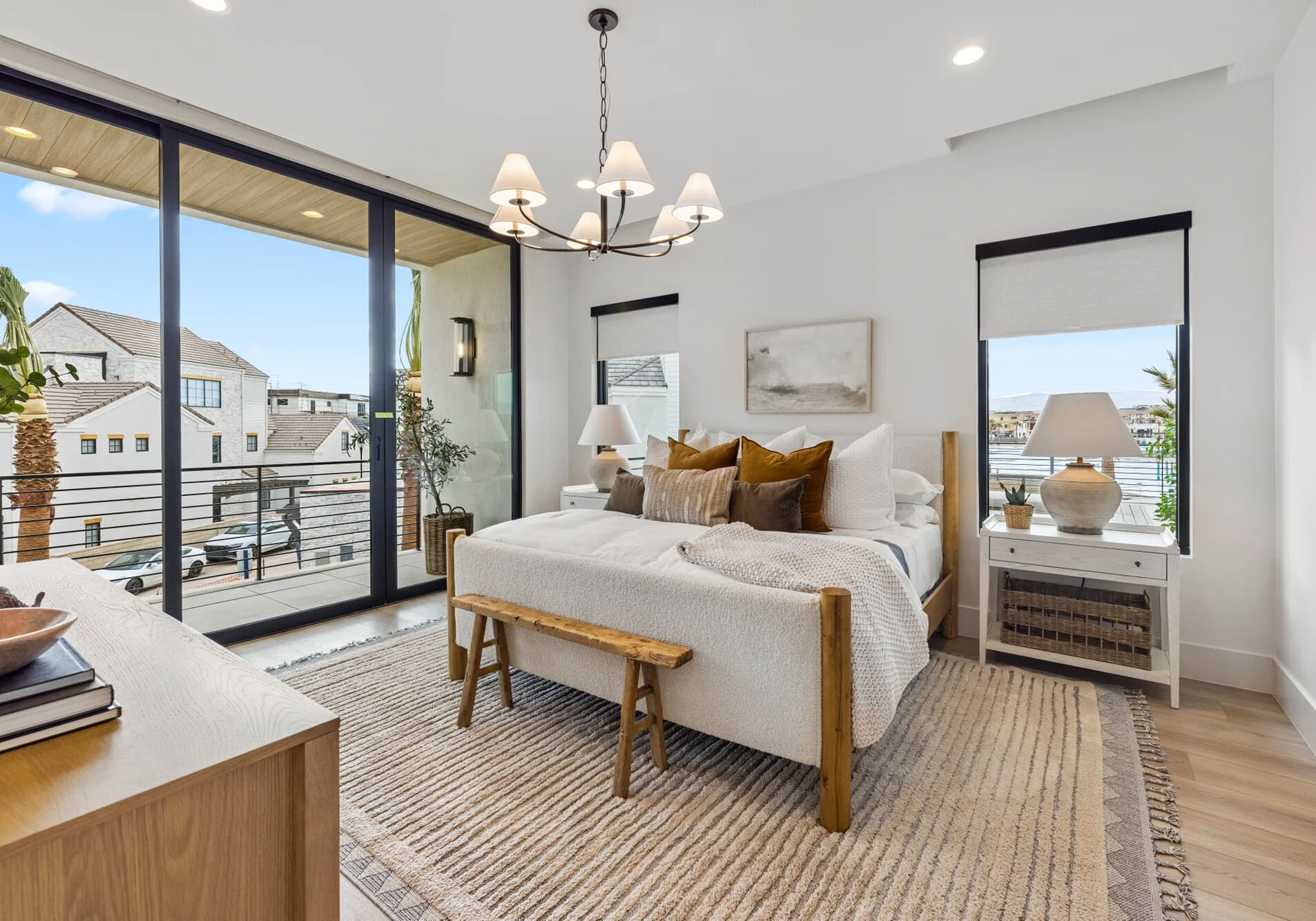 Bright master bedroom suite with a custom made white tiered chandelier.
